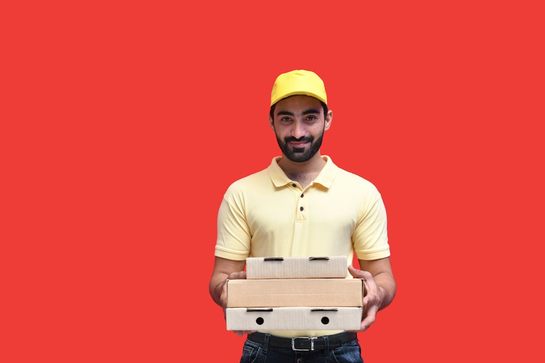 Delivery person holding a pizza box with proper packaging